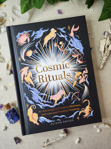 Cosmic Ritual Book Surrounded by Crystals and Sage