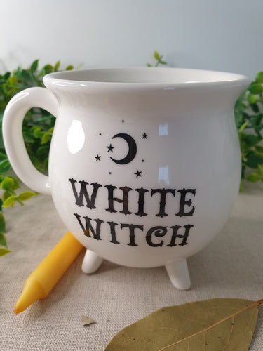 White Witch Cauldron Mug near yellow candle
