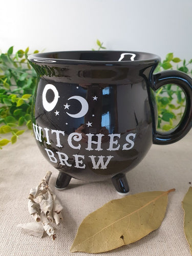 Black Witches Brew Cauldron Mug near leaves